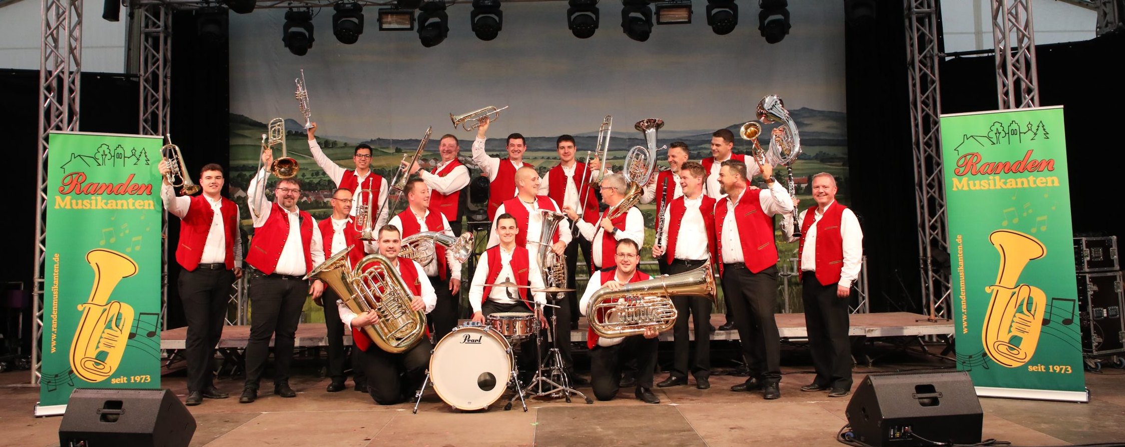 Die Randenmusikanten jubeln mit erhobenen Instrumenten auf der Bühne